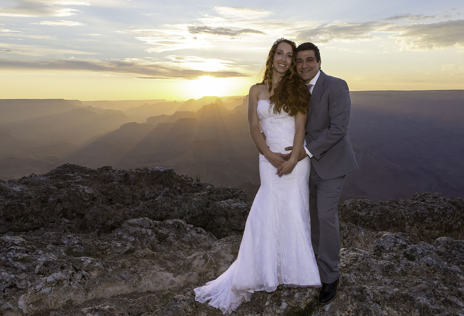 Redhead and Hispanic man getting married at the Grand Canyon during sunset.  A small wedding ceremony at Lipan Point