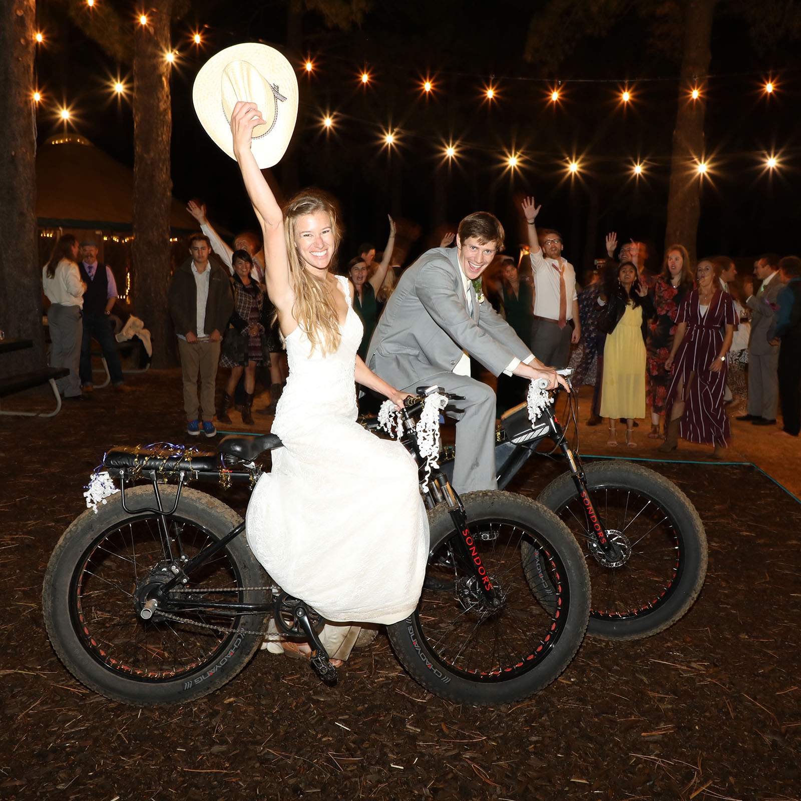 A bride and groom prepare to ride electric mountain bikes to their honeymoon yurt at the Flagstaff Nordic Center