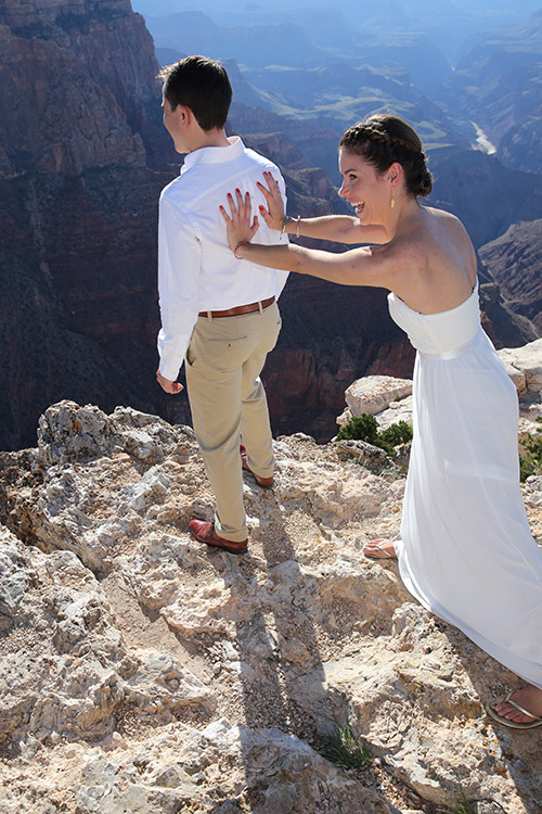 Bride pushing husband off the edge of the Grand Canyon (staged shot)