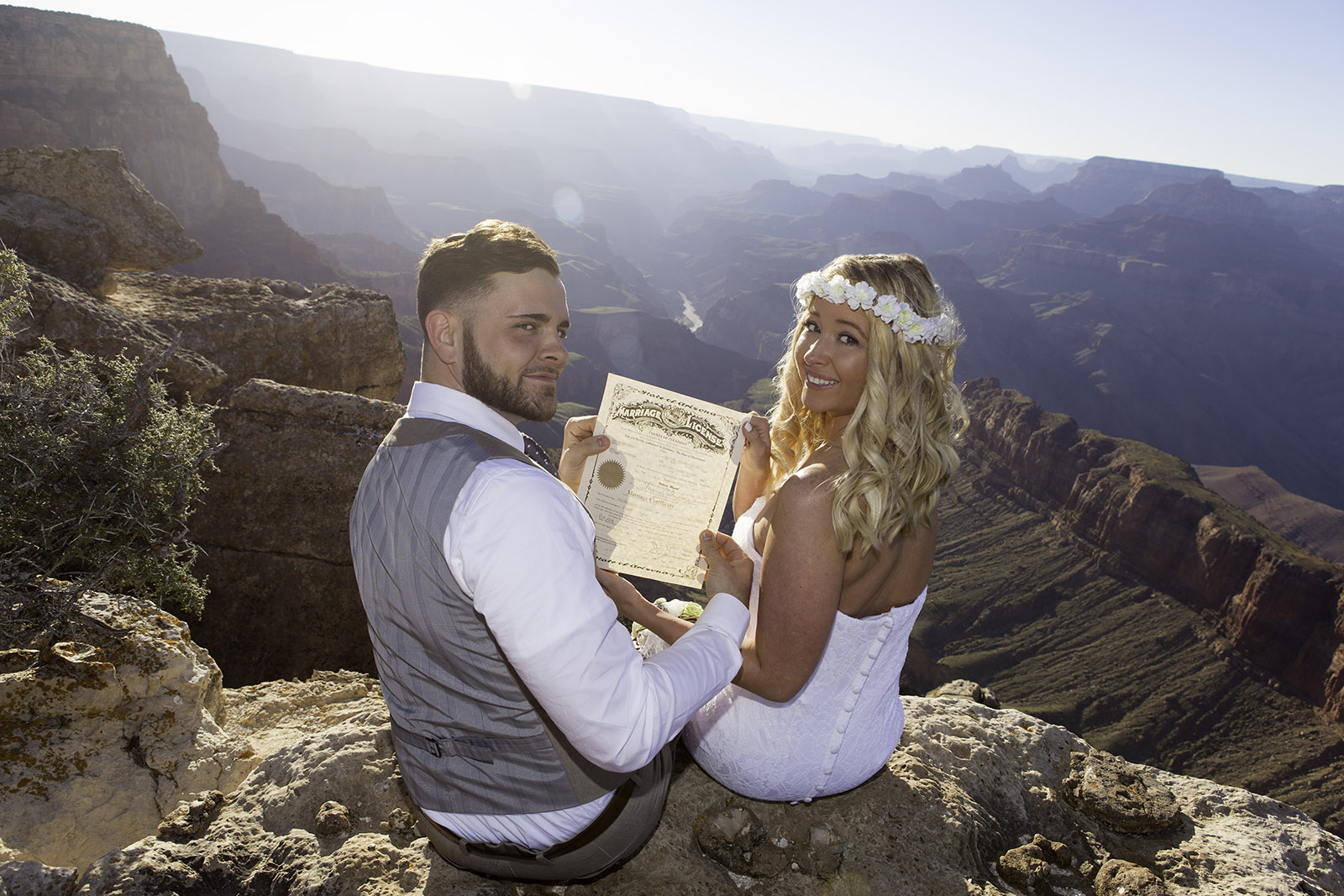 Newlyweds holding up their wedding license at the Grand Canyon at LIpan Point