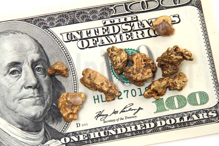 Gold nuggets and hundred dollar bill